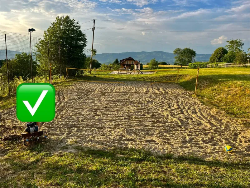 Velik rumen bager izkopava in raztovarja pesek na gradbišču. Z masivno žlico premika material, medtem ko se dviguje rahel prah.