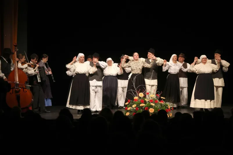 Elegantni par baskovskih plesalcev na folklornem odru Folklora Rakek