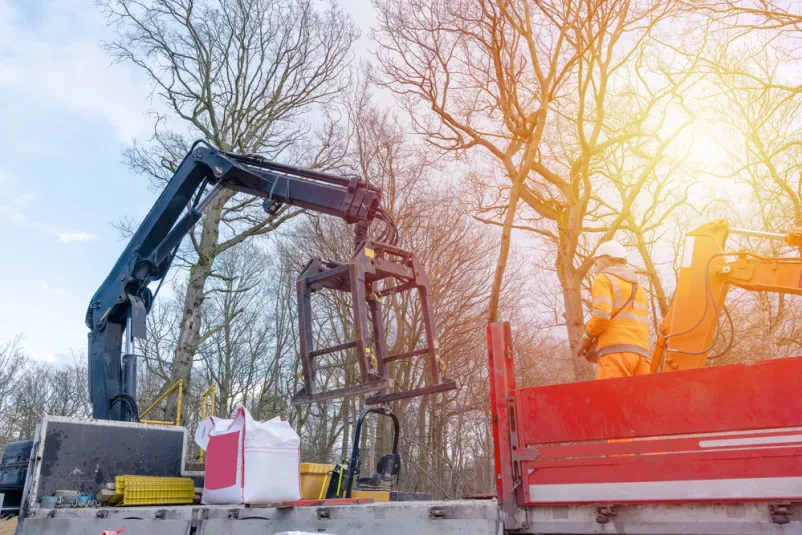 Nakladanje tovora na tovornjak s hiab dvigalom na gradbišču.