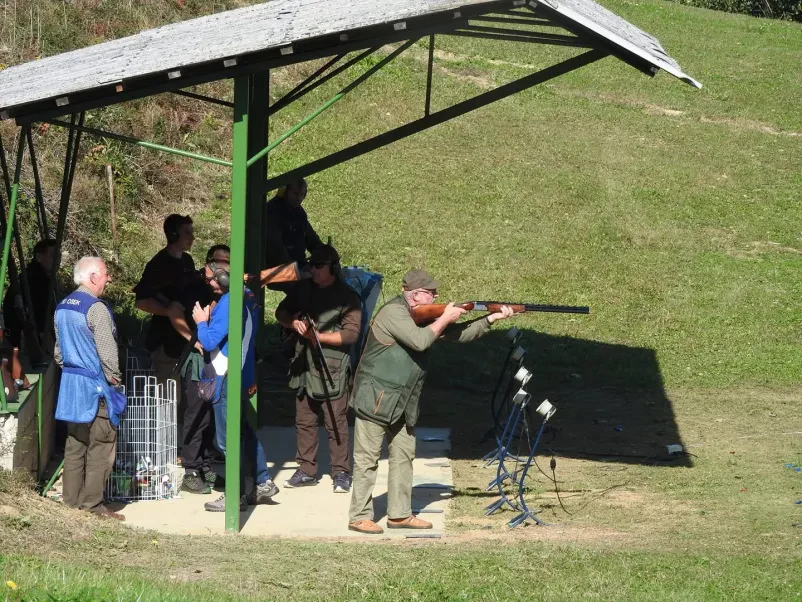 Streljanje glinastih golobov z inštruktorjem Moški se uči streljanja na glinaste golobe pod nadzorom izkušenega inštruktorja, kar je odlična izbira za teambuildinge.