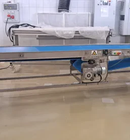 Detajlen posnetek večpasovnega transportnega sistema, zgrajenega iz kakovostnih inox konstrukcij, ki je ključnega pomena za optimizacijo logistike.