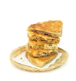 Izbor hrustljavih burekov, ki so značilni za ponudbo Najboljši burek in pizza Ljubljana Polje, je zložena v pleteni košari.