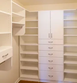 Prostorna vgradna omara v beli barvi, zasnovana za optimalno organizacijo in shranjevanje oblačil, kar je bistveno za urejen dom.