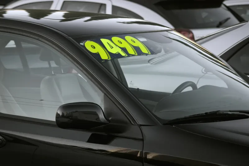 Rabljeno vozilo z oznako 'Naprodaj' Beli avtomobil z oznako
