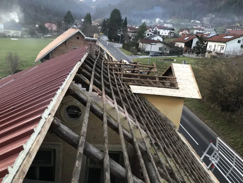 HIAB dvigalo dviguje strešnike na streho, kar poudarja storitve s HIAB dvigalom in kiper prevozi Ljubljana okolica Dolenjska.
