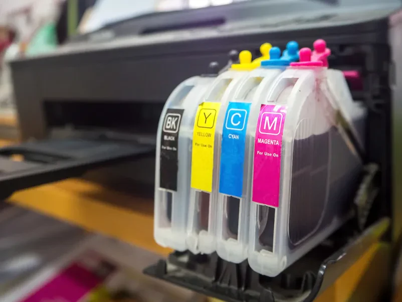 Bližnji pogled na kartuše digitalnega tiskalnika Bližnji posnetek CMYK toner kartuš v digitalnem tiskalniku za živahne in natančne barvne odtise.