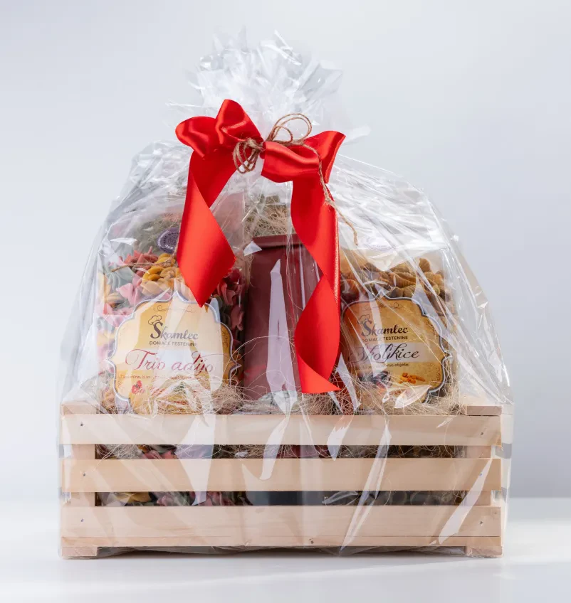 Privlačen darilni paket testenin Lepo oblikovan darilni paket z izborom kakovostnih domačih testenin, pripravljen za posebne priložnosti.