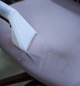 Od blizu posneta sesalna šoba čistilnika, ki se uporablja za temeljito čiščenje oblazinjenega stola, zagotavlja higieno.