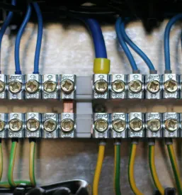 Podroben pogled na organizirano električno ožičenje in varovalke v stikalni omarici, ki kaže na skrbno izvedbo električnih inštalacij.