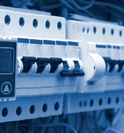 Natančen pogled na kompleksno električno napeljavo znotraj razdelilne plošče, ki prikazuje komponente za zanesljivo distribucijo električne energije.