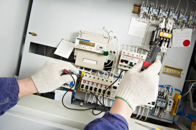 Električar z multimetrom natančno meri visoko napetost v plošči, nujno za kvalitetne elektroinštalacije Nova Gorica, Goriška.