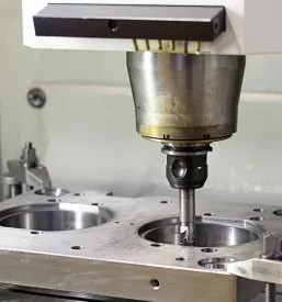 Sodoben CNC rezkalni stroj med obdelavo kovinskega dela, poudarjajoč visoko tehnologijo in natančnost v industrijski proizvodnji.