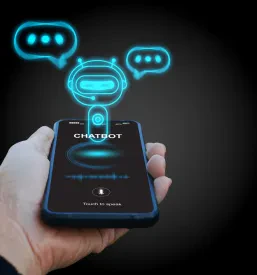Roka drži pametni telefon z virtualnim zaslonom, ki prikazuje digitalnega chatbota – konverzacijskega agenta, ki posnema človeški govor in pomaga pri spletnih informacijah.