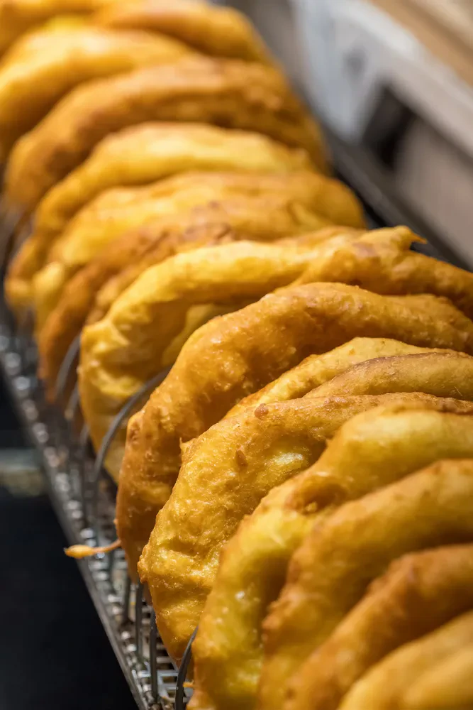 Peka langošev v vročem olju na sejmu Priprava tradicionalnih madžarskih langošev na sejmu, kjer se cvrejo v vročem olju, kar je značilno za peka langošev Murska Sobota in okolica. Prikazuje kultura dogodka.