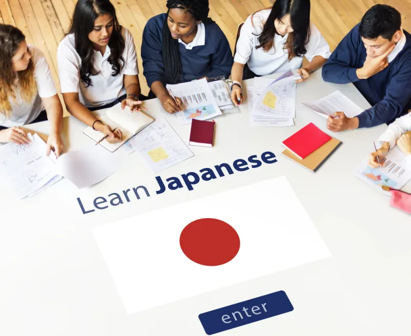 Študenti se učijo japonščine Skupina različnih študentov je zbrano osredotočena na učenje japonščine, zapisujejo si opombe na papirje, kar kaže na učinkovito poučevanje japonščine Bled, Gorenjska.