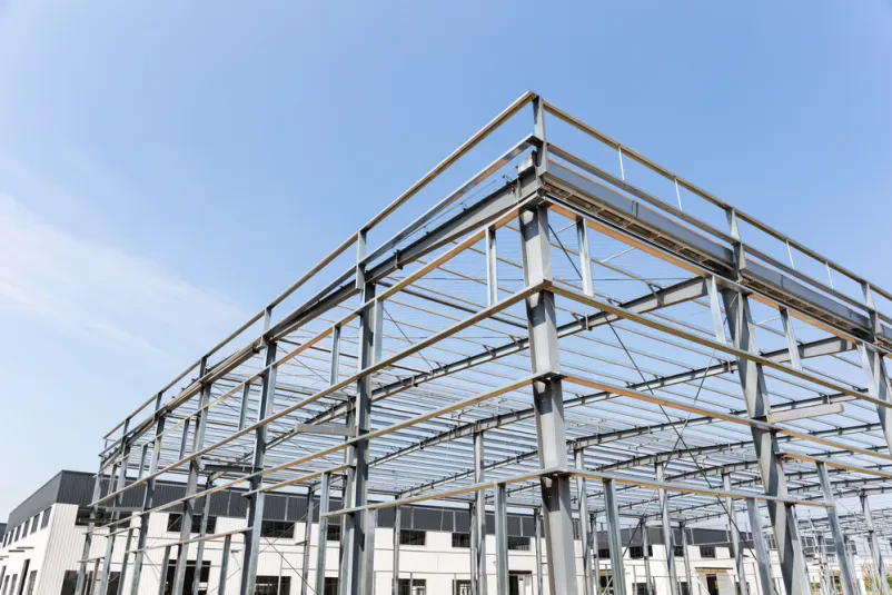 Jeklena konstrukcija tovarne v gradnji. Natančni statični izračuni za jeklene konstrukcije so ključni za stabilnost in varnost industrijskih objektov.