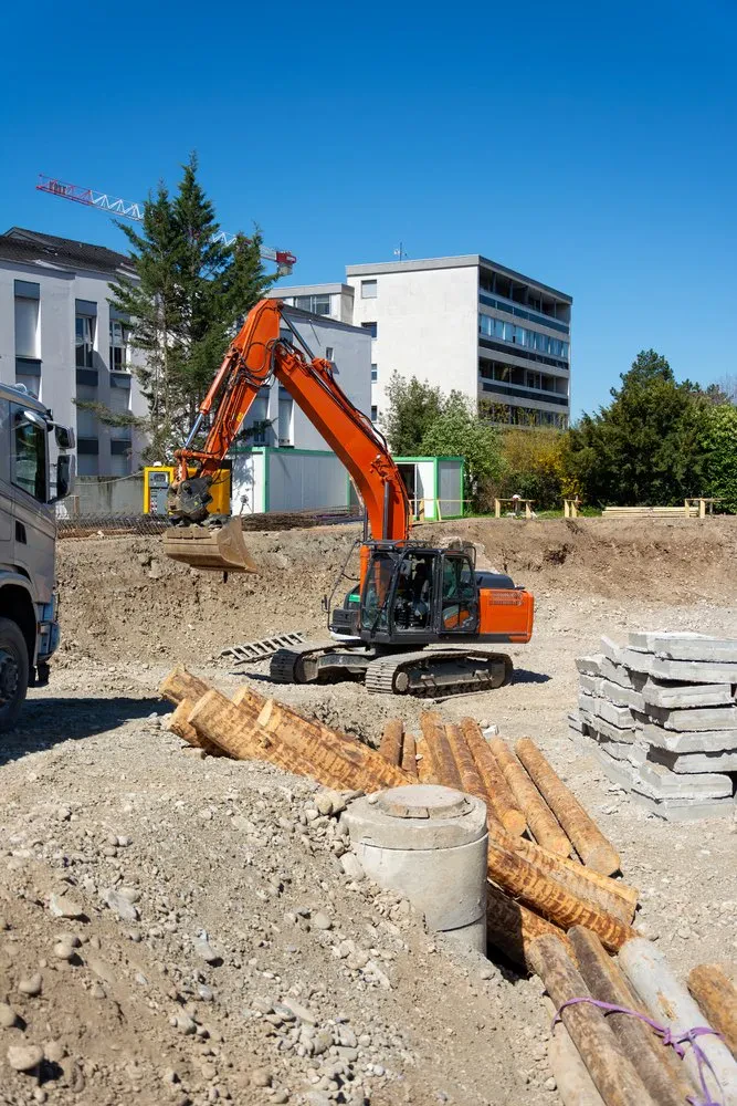 Gosenični bager v globoki izkopni jami Gosenični bager v globoki gradbeni jami z betonskimi ploščami in lesenimi piloti, pripravljen za zahtevna zemeljska dela Posavje.