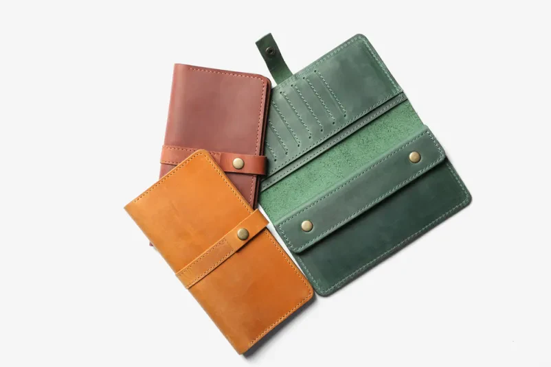 Elegantne denarnice na beli podlagi Eleganten pogled od zgoraj na moderno oblikovane denarnice v različnih barvah, ki so primerni usnjeni izdelki za vsakdanjo uporabo.