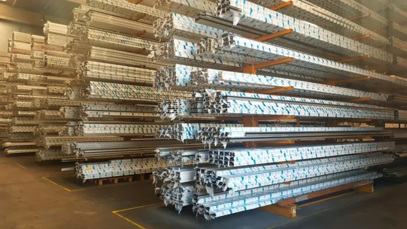 Proizvodnja aluminijastih komponent v delavnici Izkušen tehnik med delom na stroju za izdelavo vrhunskih industrijskih profilov za različne sisteme aluminijastih konstrukcij.