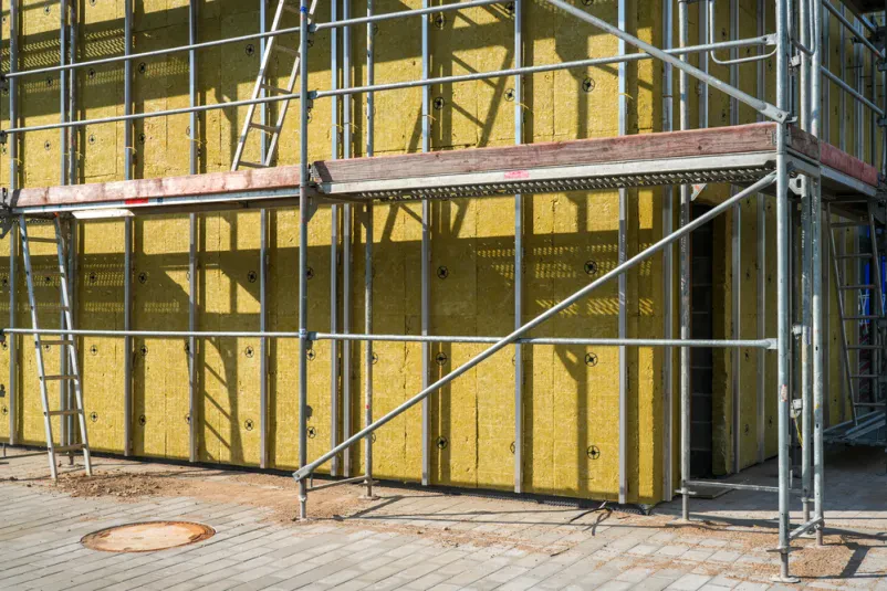 Detajl namestitve izolacijskih plošč iz mineralne volne na zunanje stene med fasadnimi deli, kar je ključno za kakovostne fasade, knauf suhomontažo Celje in okolica.