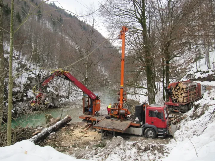 Spravilo lesa z žičnico Dva gozdarja nadzorujeta delovanje sodobne gozdarske žičnice za učinkovito spravilo lesa s težko dostopnega terena.