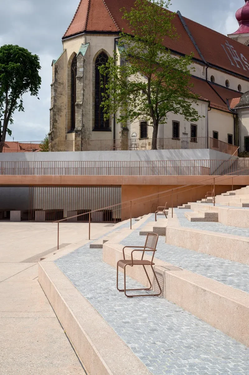 Ženska se sprehaja po modernih zunanjih betonskih stopnicah. Ta Izdelava in montaža betonskih komponent za dvorišča Slovenija zagotavlja trajnost in estetiko.