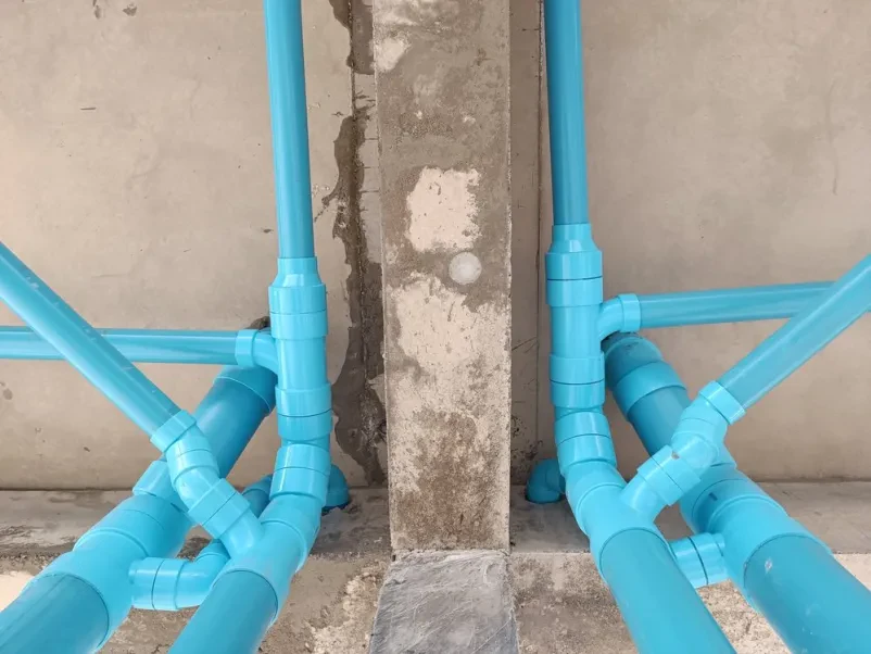 Modre PVC vodovodne cevi so nameščene okoli betonskega stebra. Odlična je kvalitetna izvedba vodovodnih in odtočnih napeljav Zasavje.