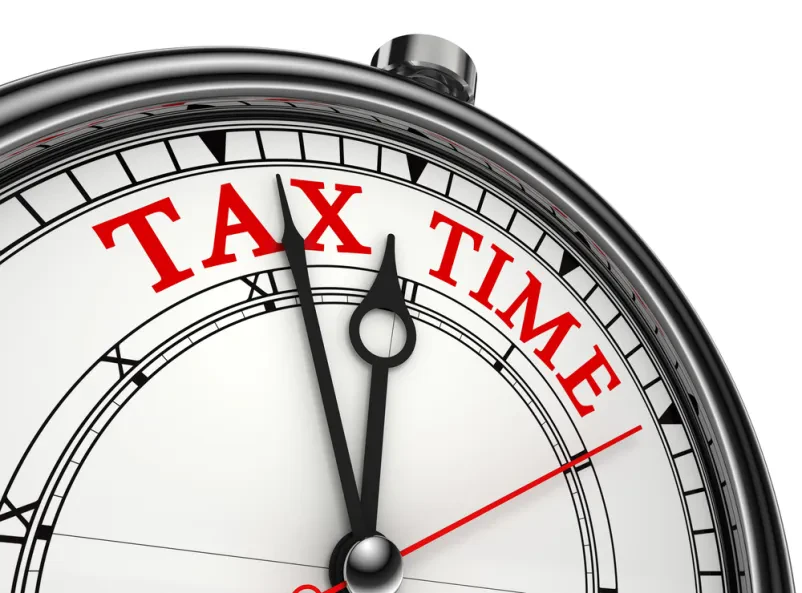 Povečava konceptne ure, ki prikazuje besedo »TAX« (davek), spominja na pomembnost pravočasne ureditve finančnih zadev.