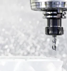 Izjemno podroben posnetek obdelave kovine z rezkalnikom. Natančni rezi in odrezki so vidni, ko nastajajo med industrijskim rezkanjem.