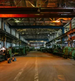 Industrijska delavnica s težkimi stroji za obdelavo kovinskih cevi, prikazuje splošno industrijsko okolje.
