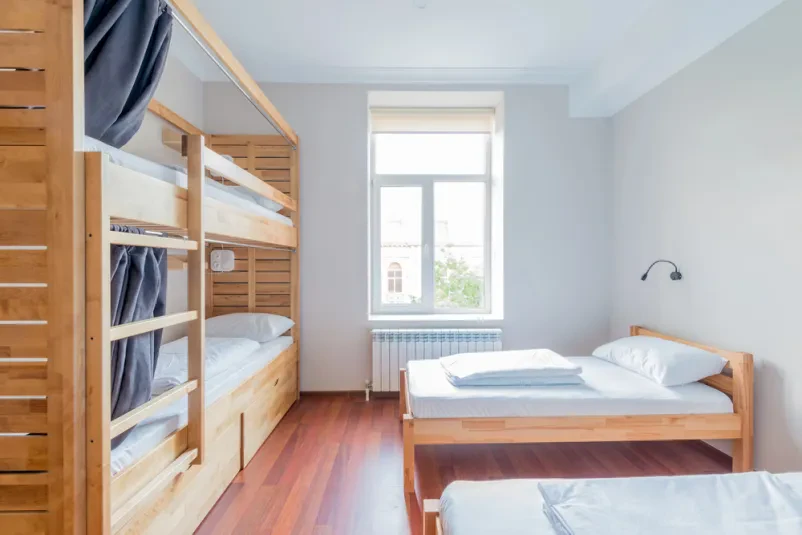 Udobne postelje v skupni sobi hostla Več udobnih postelj v skupinski sobi hostla, ki zagotavljajo poceni namestitev. Ponuja ugodne sobe Prestranek za večje skupine.