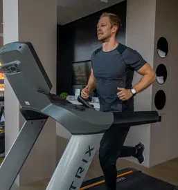 Moški izvaja mrtvi dvig z olimpijsko palico, kar je ključna vaja za celotno telo. Pomembna je pravilna drža in nadzor gibanja.