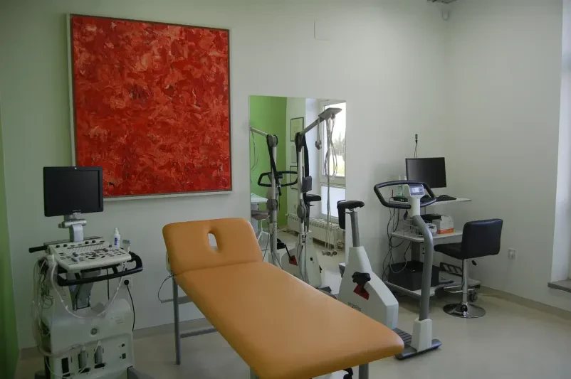 Detajl roke pacienta z elektrodami, ki prikazuje EKG holter preiskavo za spremljanje srčne aktivnosti.
