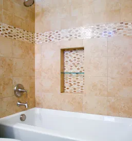 Sodobna in sveže prenovljena kopalnica z modernimi keramičnimi ploščicami na stenah in tleh, ki poudarjajo eleganco.