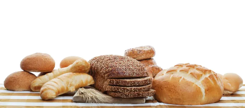 Raznovrsten pekovski kruh Široka paleta sveže pečenega kruha in različnih žemelj, lepo razporejenih na beli podlagi, kar poudarja bogato ponudbo pekovskih izdelkov.