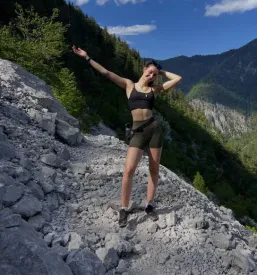 Aktivna osebna trenerka za vodene vadbe, ki je na aktivnem izletu v gorah.
