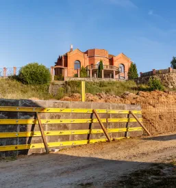 Opaž in armatura so skrbno pripravljeni za vlivanje betona, kar je ključni korak pri izdelavi betonske škarpe. Na gradbišču potekajo zemeljska dela in zidarska dela za stabilizacijo terena.
