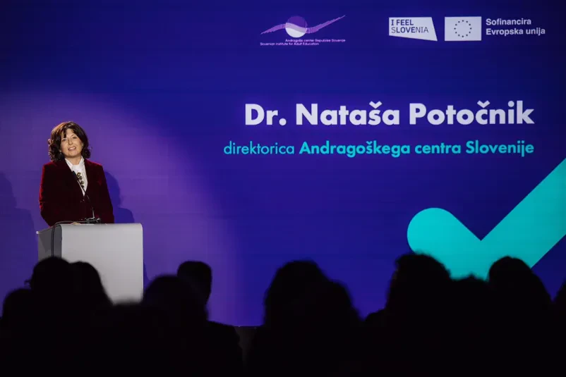 Več študentov zbrano dela na osebnih računalnikih v sodobni učilnici. Poudarek je na praktičnem usposabljanju in pridobivanju digitalnih spretnosti.